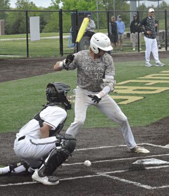 WITH EXCELSIOR SPRINGS coach Aaron Holst and some spectators watching in the background, junior Kota Triplett (No. 32) takes a pitch low May 4 against visiting Willard. SHAWN RONEY | Staff