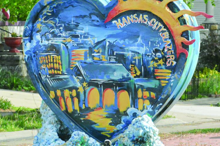 THE PARADE OF HEARTS installation on display in Excelsior Springs, with artwork by Gwynevere Buie,” features a cityscape mural on one side. Titled “Splash!”, the piece also pays tribute to the swim team the Kansas City Blazers. SHAWN RONEY | Staff