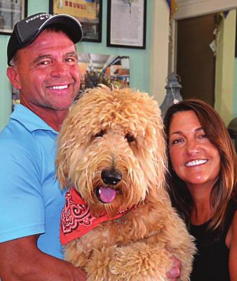 AT BRUNKE, owners Gary and Kim Sanson show off their golden doodle, also name Brunke, which they adopted while renovating their building.