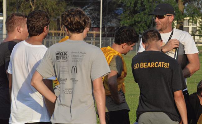 AARON RODENBERG (right), Orrick’s new varsity 8-man football coach, offers a few final words after a summer team camp session. SHAWN RONEY | Staff
