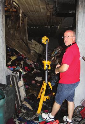 RICHMOND Salvation Army Director Phil Powers shows fire damage makes a shambles of the organization’s new building.