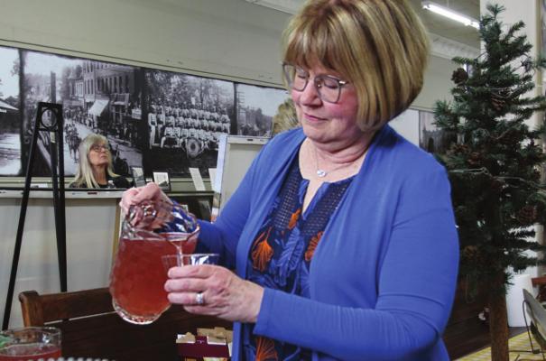 IN PREPARATION for opening night of the Cooley Lake Art Show on April 8 at the Excelsior Springs Museum and Archives, volunteer Beth Humphreys pours cool drinks for guests.