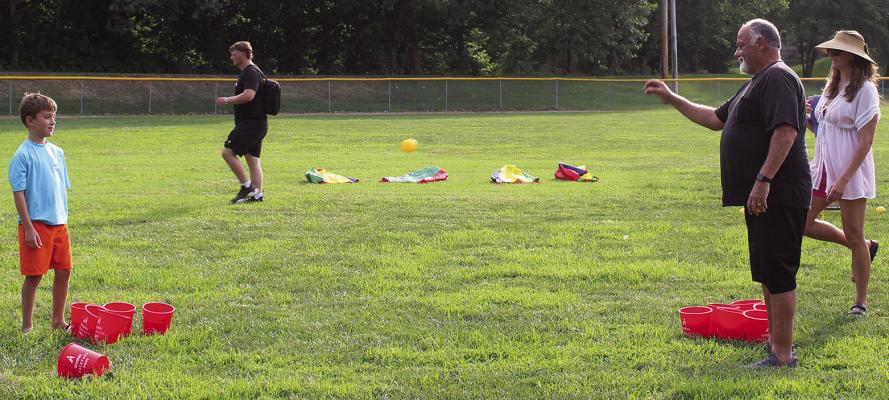 ORION BRYAN (from left), Rick Willis and Ashley Bryan try their luck at one of the evening’s lawn games.