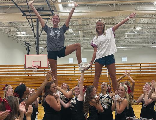 EXCELSIOR SPRINGS HIGH SCHOOL cheerleaders raise Coach Paige Colgan (left) during a routine, reflecting her role working with students both in the classroom and through athletics. MIRANDA JAMISON | Staff