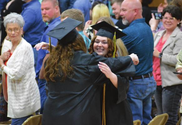 SAVANNAH BARTLEY hugs a classmate during the opening processional. SHAWN RONEY | Staff