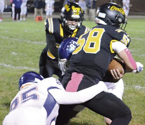 XAVIOR GASKINS (right) attempts to break free from two tacklers during Orrick’s regular-season finale with St. Paul Lutheran of Concordia. SHAWN RONEY | Staff