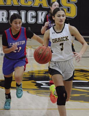 SHAWN RONEY | Staff MIREYA GONZALES of Lexington pursues Anela Fletcher as Orrick pushes the tempo during a recent varsity girls-boys doubleheader. The Orrick girls fall 68-30, putting them at 3-6 overall as 2025 approaches.
