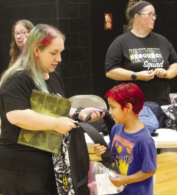 WITH HIS mother’s help, Michael Cruz (center) picks out a backpack from the resource fair.