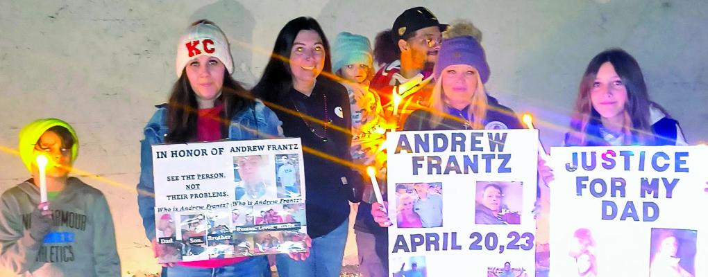 FAMILY MEMBERS and supporters lift signs and candles during the Excelsior Springs Christmas Parade to call for answers in Andrew Frantz’s disappearance. Submitted