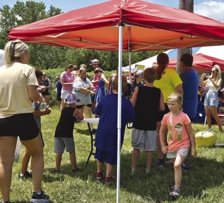 CHILDREN HAND raffle tickets to the R Mac’s Fireworks giveaway host to call the winners. MIRANDA JAMISON | Staff