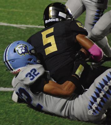 NICK MUBANGA (right), a first-year high schooler at Excelsior Springs, keeps a grip on the football when he’s brought down by Grandview’s Josiah Davis-Mahoney. SHAWN RONEY | Staff