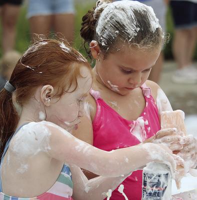 KINSLEY BUCKMAN (right) puts her creativity to work while decorating a pretend doughnut. MIRANDA JAMISON | Staff