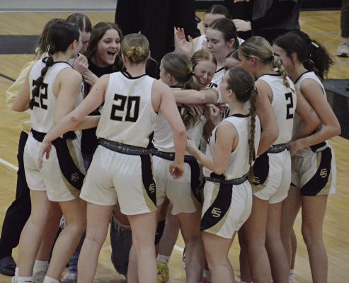 MEMBERS OF the Excelsior Springs varsity girls basketball team gather in jubilation after pulling out a 48-45 victory over Richmond to win the Class 4 District 15 title. SHAWN RONEY | Staff