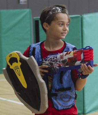 NICK DEFELICE grips a foam shield and blaster while scanning for the next target.
