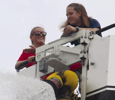 COMMUNITY CENTER and fire department staff team up to cool down families with a blast from the ladder truck hose. MIRANDA JAMISON | Staff