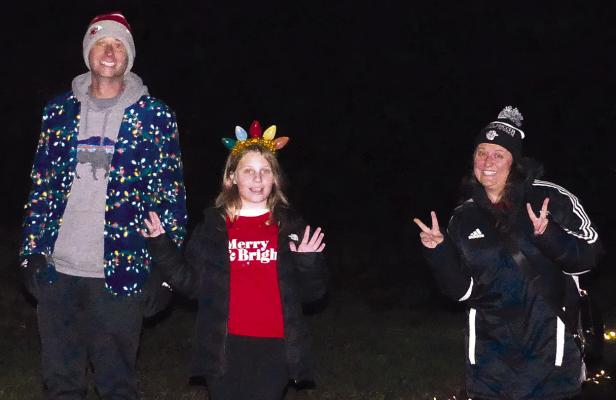 Ben Ruby (from left), Mackenzie Ruby and Katrina Yoakum strike a pose as they jogged through the lane of lights. ELIZABETH BARNT | Staff