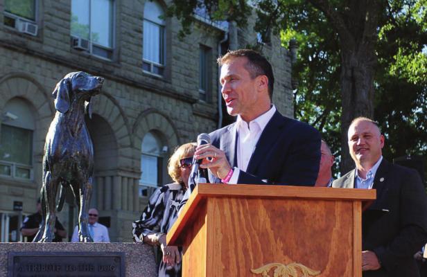 J.C. VENTIMIGLIA | Staff THEN-GOV. Eric Greitens gives Sen. George Graham Vest’s “Eulogy to a Dog,” written in honor of Old Drum, during a bill-signing ceremony in June 2017 on the Warrensburg square in front of the dog’s statue. Behind Greitens stands Sen. Denny Hoskins, whose bill made Old Drum the official state historical dog.