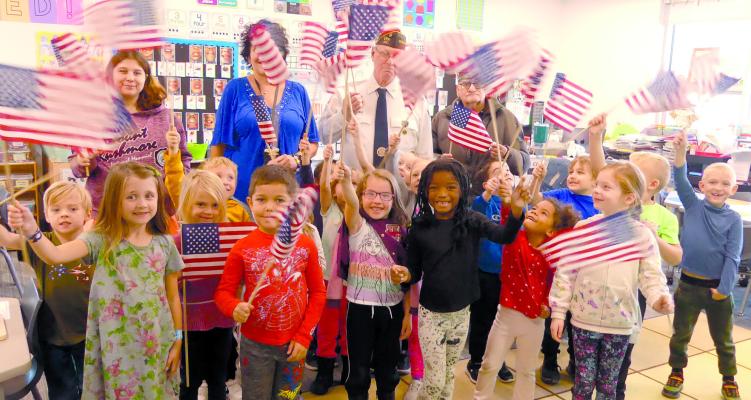 CORNERSTONE KINDERGARTNERS in Lins Haskell-Sherman’s class wave flags in observance of Veterans Day. ELIZABETH BARNT | Staff