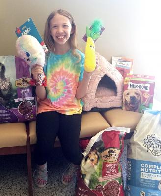 AUSTYN FILLEY SITS with all her donations from family and friends after wishing for her birthday to give to the animal shelter in Exelsior Springs. SUBMITTED