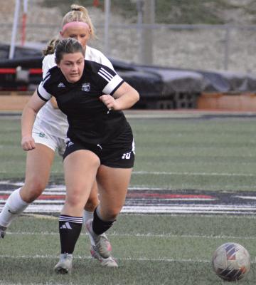 GRACIE CARDER shields the ball as she fights for possession during Excelsior Springs’ clash with Smithville in Greater Kansas City Suburban Conference-Blue Division play. SHAWN RONEY | Staff