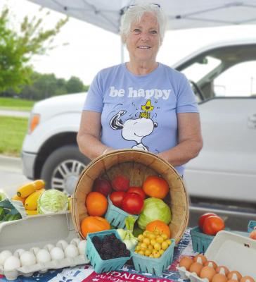 FARM FRESH goodness comes to Excelsior every Wednesday morning at the Community Center Farmers Market. Colleen Rhodus stands with samples of vendors’ fresh produce and eggs. TARA ALTIS | Staff