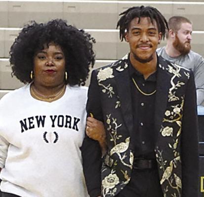 SENIOR ZHIA HYCHE (right), son of Eva Bowman and Tyler Bowman, is escorted by his mother.