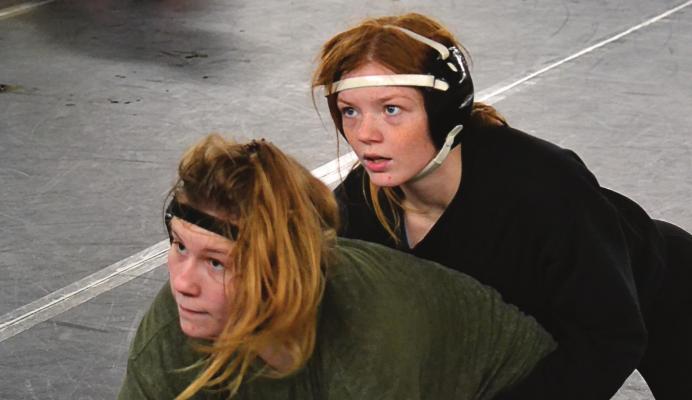 SENIOR PAIGE BARBER, top, works on technique with junior Vada Burton. DUSTIN DANNER | Staff