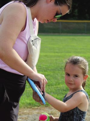 WITH HELP FROM her mother, Josie Harkins gets ready to join a field activity during the Parks and Recreation Month kickoff event. MIRANDA JAMISON | Staff