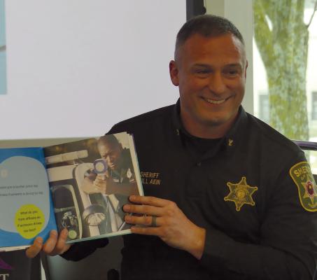 CLAY COUNTY SHERIFF Will Akin joyfully shares his passion for law enforcement while reading police centered children’s books during Hero Story Time at Mid-Continent Public Library Excelsior Springs Branch. ELIZABETH BARNT | Staff