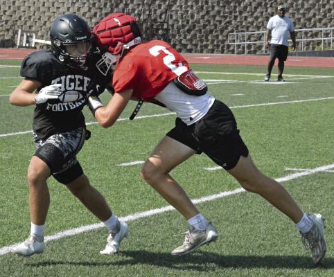 HAYDEN O’DELL (left) keeps his eyes upfield as he fights off a block by Richmond’s Bryer Farnan.