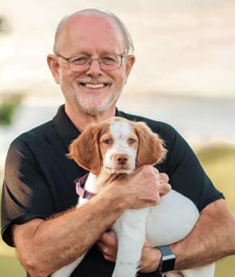 DR. PETE RUCKER holds a young spaniel. DIMPLES AND DAYDREAMS | Submitted