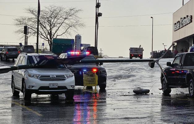 TWO VEHICLES WERE damaged when strong winds knocked down a light pole in the Dollar General parking lot. MIRANDA JAMISON | Staff