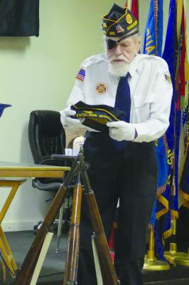 AMERICAN LEGION Post 256 adjutant Herschel Harrington places the American Legion cap on top of a tripod of rifles in preparation of the ceremony. ELIZABETH BARNT | Staff