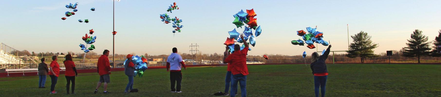 DOZENS OF BALLOONS fly from the middle of the Richmond High School football field in celebration of International Day for People with Disabilities.