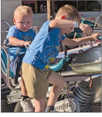 MILO (LEFT) AND CARTER CAPPS take a spin on the motorcycle ride at the carnival. MIRANDA JAMISON | Staff