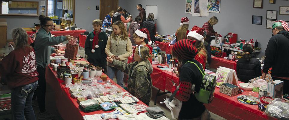 EVENT HELPERS GUIDE participants as they choose Christmas presents for family members while volunteers wrap the gifts for children to take home. MIRANDA JAMISON | Staff
