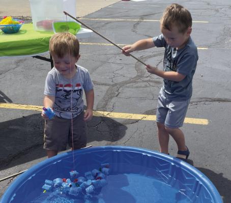 LINCOLN AND DANIEL, grandsons of Apple Bus/First Student manager Kim Green, enjoy some swimming pool fishing during the “Big Bus, No Big Deal” event on Aug. 6. Bus barn drivers and employees play with children in safe areas while parents take the opportunity to try driving a school bus.