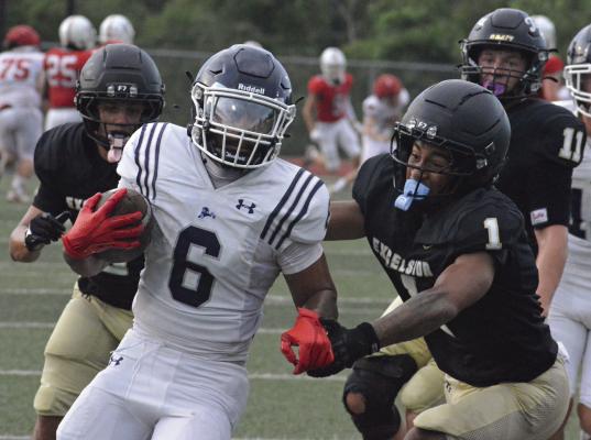 NICK MUBANGA (right) leads in pursuit of the football during the Tigers’ preseason jamboree scrimmage with Oak Park. Excelsior Springs also scrimmaged with East Buchanan. SHAWN RONEY | Staff