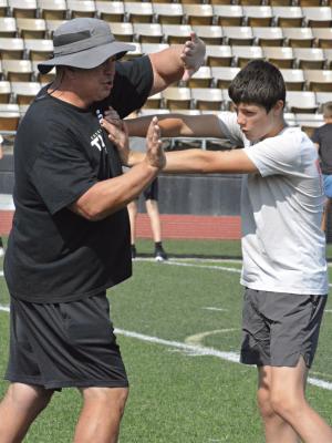 EXCELSIOR SPRINGS HIGH SCHOOL Assistant Coach Jeremy Hays (left) and Paxton Lingle demonstrate hand fighting and pressing techniques during a recent football camp at Tiger Stadium. Following the camp, Excelsior Springs Varsity Coach Jake Danneman took some of his Tigers to Kearney for a series of Tuesday morning 7-on-7 sessions. The series concluded Tuesday. In July, Excelsior Springs is slated to host some multiteam scrimmages.