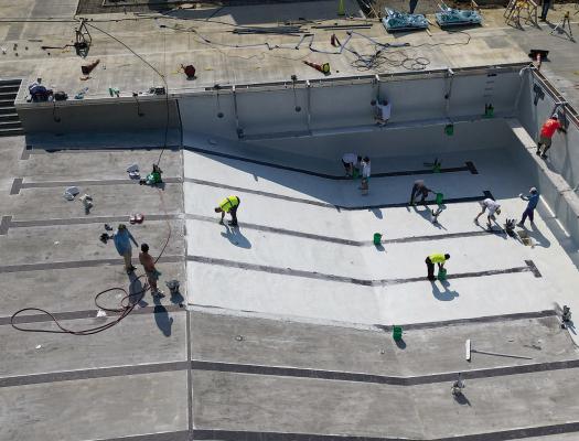 WORK CREWS COMPLETE tile and plaster inside the pool.