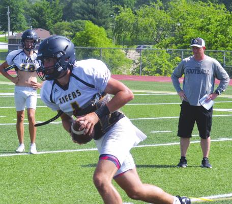 QUARTERBACK CHANCE MORELAND, who will be a senior this fall at Excelsior Springs High School, carries the football around the edge during drills at team camp at Tiger Stadium. DUSTIN DANNER | Staff