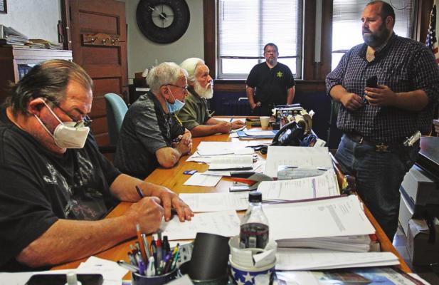 COMMISSIONERS, from left – Gary Wilhite, Bob King and Dave Powell – listen as Ray County Sheriff Scott Childers shows cell phone photos of another jail escape attempt made about three weeks earlier. J.C. VENTIMIGLIA | Staff