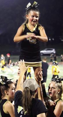 SOPHIA WALSTON reaches the top of a stunt as fellow cheerleaders support her from below.