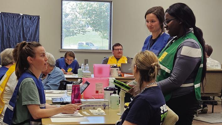 VOLUNTEERS USE A language translation device during a simulated emergency training. MIRANDA JAMISON | Staff