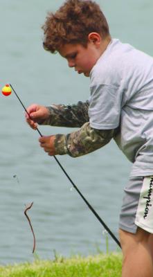HUNTER H. CHECKS his fishing line during a day at the water’s edge. SHARON DONAT | Staff