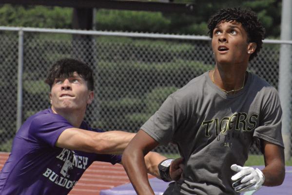MARQUEZ McCANT (right) watches a pass thrown his way as he heads toward the end zone during a 7-on-7 scrimmage between Excelsior Springs and Kearney. This week’s session was the first of three straight Tuesday morning 7-on-7 sessions McCant and the Tigers will attend at Kearney High School. SHAWN RONEY | Staff