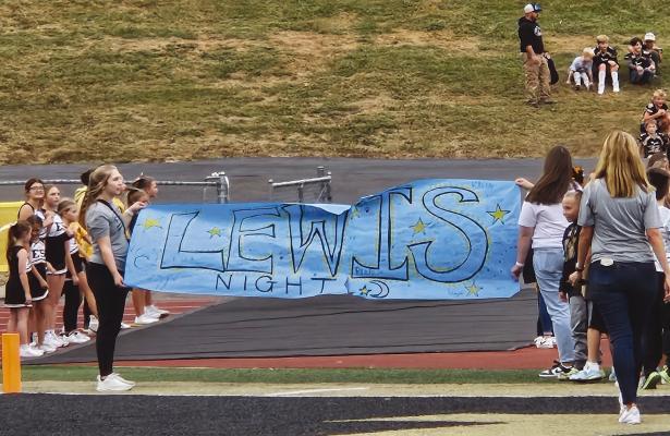 EXCELSIOR SPRINGS HIGH SCHOOL hosts Lewis Night at the football game. Lewis Elementary students hold a banner and form a tunnel for the Excelsior Springs High School football players to run through on Lewis Night.