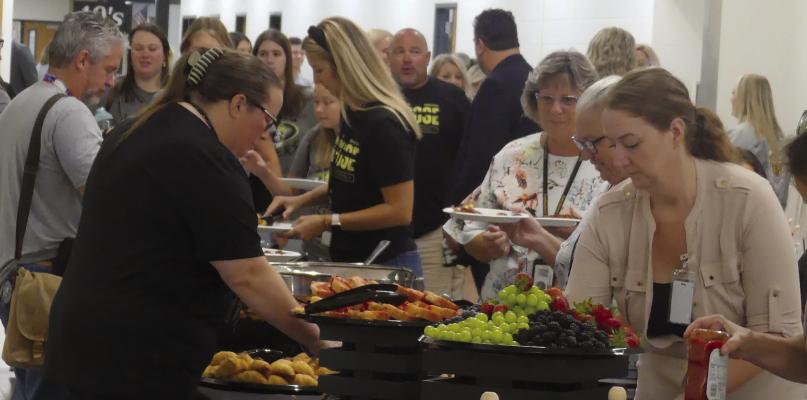 NEW FACES and returning school district staff eat breakfast together to kick off the school year.