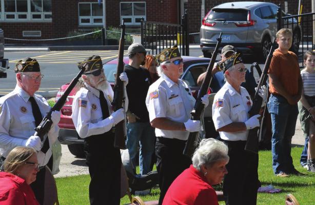 THE HONOR GUARDSMEN raise their rifles to prepare to fire volleys in honor of fallen service members.
