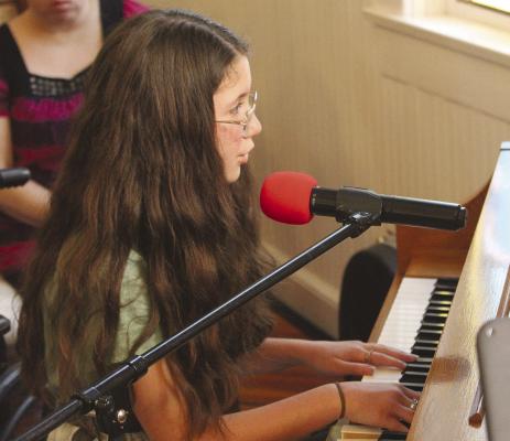 BREE POLING focuses on the keys while singing a selection.